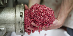Butcher Justin Taylor collects ground beef as it exits the grinder at the Wyanet Locker in Wyanet, Illinois, U.S., on Thursday, April 26, 2012. Cattle futures rose for a second day on signs that the biggest buyers of U.S. beef will keep purchasing the meat, even after the country reported its first case of mad cow disease in six years. Photographer: Daniel Acker/Bloomberg via Getty Images